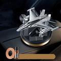 Solar powered rotating silver fighter jet car air freshener ornament on a dashboard.