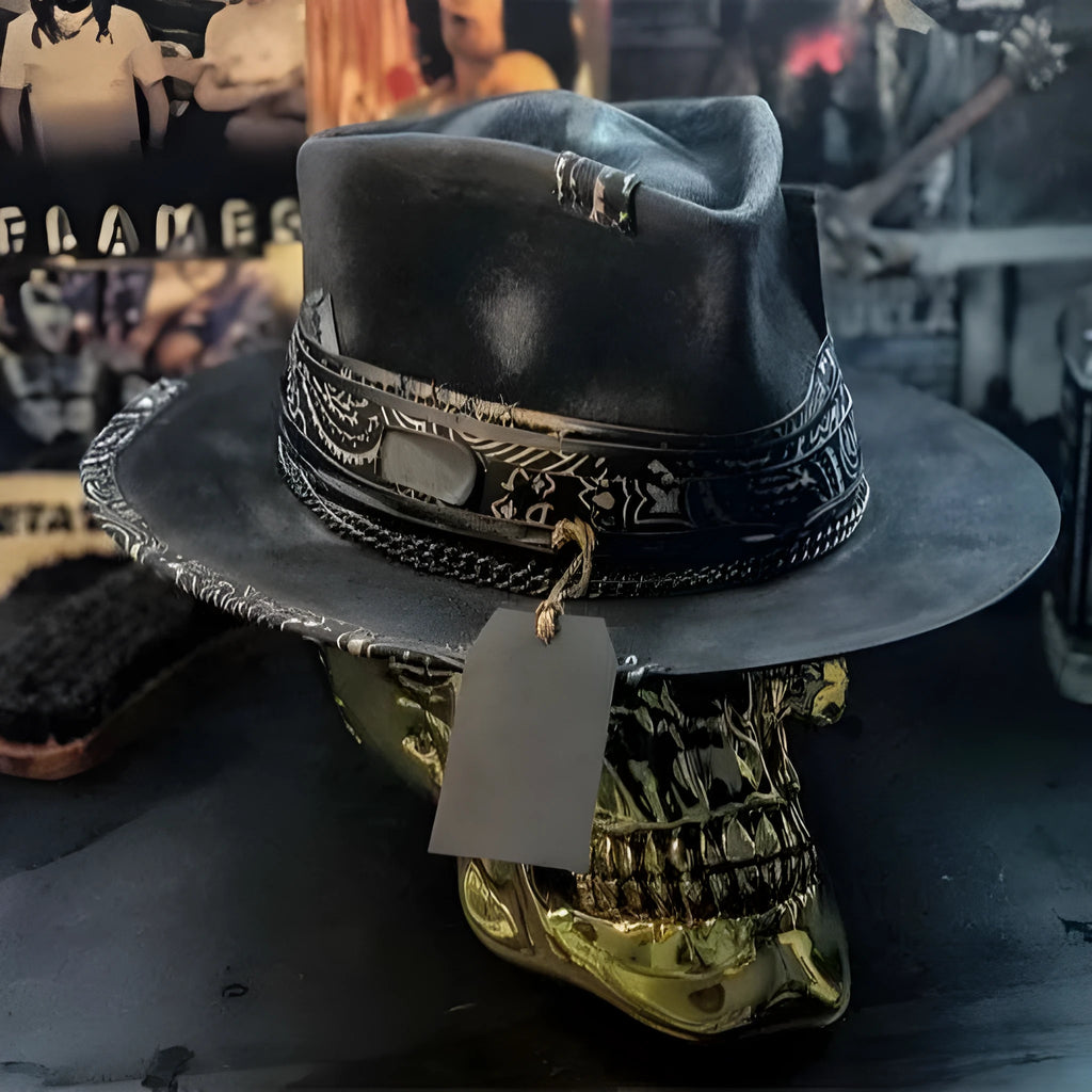 Handmade black wool felt skull hat with a pointed conical crown on a plain background.