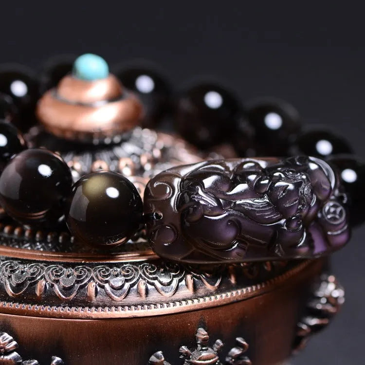 Polished crystal Pi Xiu bracelet with geometric ethnic design on a wrist, showing double eye ice stone pattern.