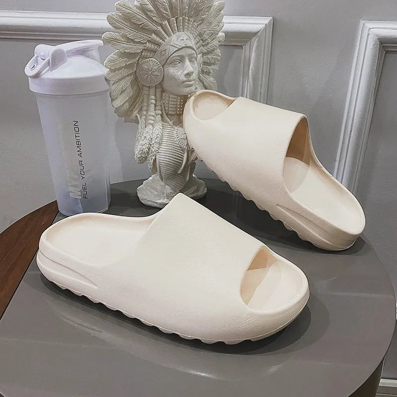 Women's thick-soled EVA beach slippers in beige, shown on a sandy background.