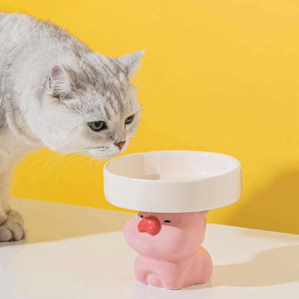 Raised ceramic cat food bowl in an animal theme design on a white background
