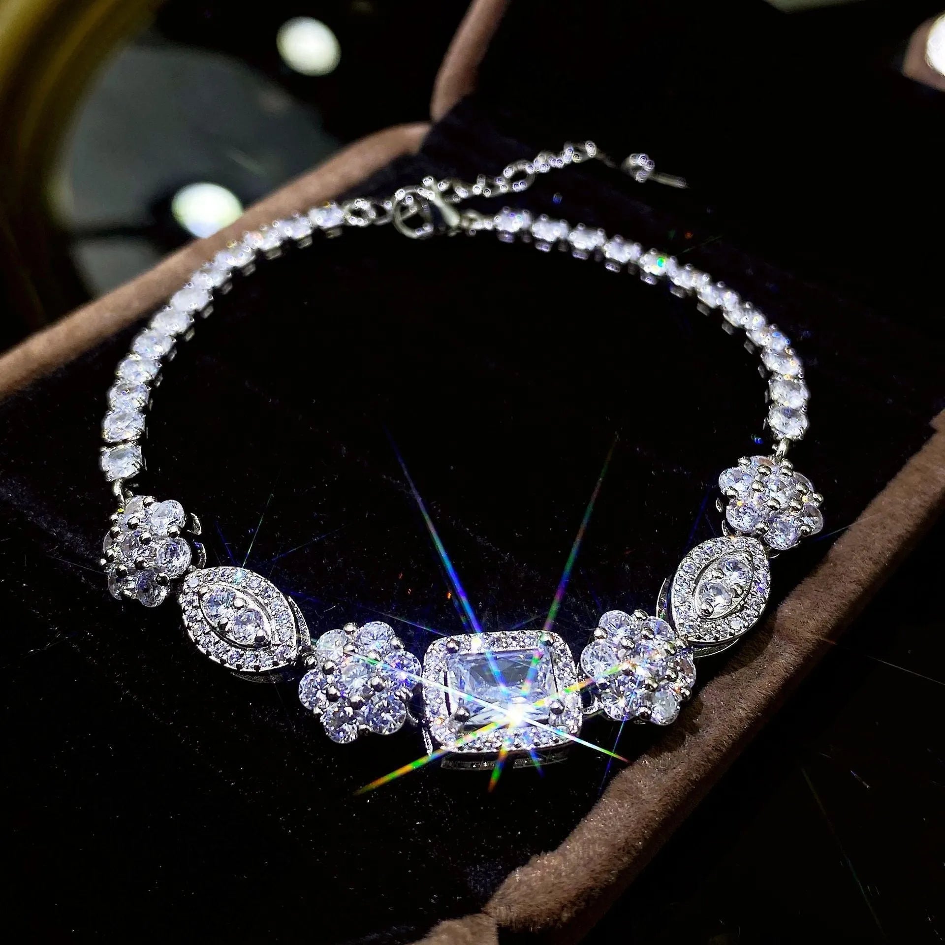 Women's geometric silver bracelet with inlaid white zircon stones on a wrist, showing adjustable clasp.