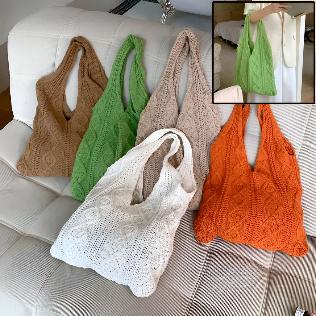 Women's white hollow knitted crochet tote bag with double shoulder straps, shown on a table.