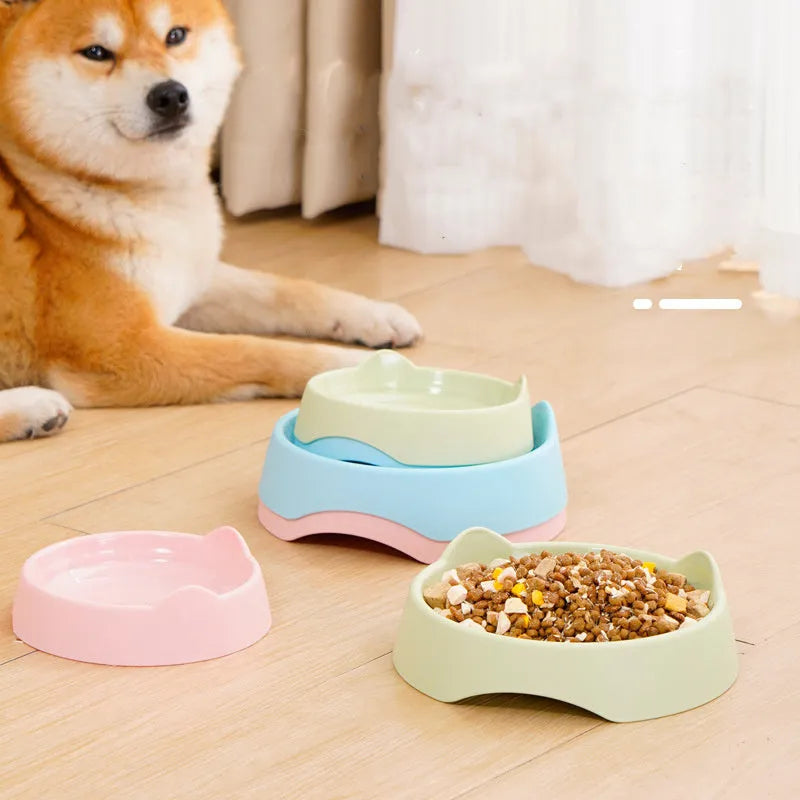 Blue ceramic dog slow feeder bowl with internal maze design, shown next to a green and pink version.