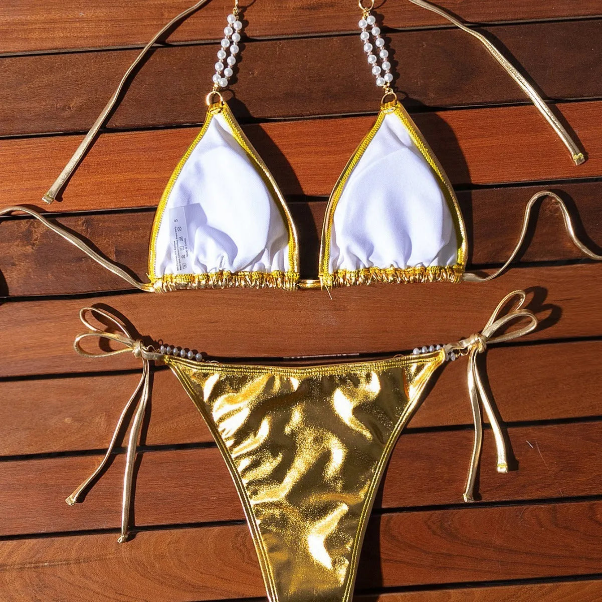 Gold women's halter bikini with front lace-up tie and decorative pearl chain detail.
