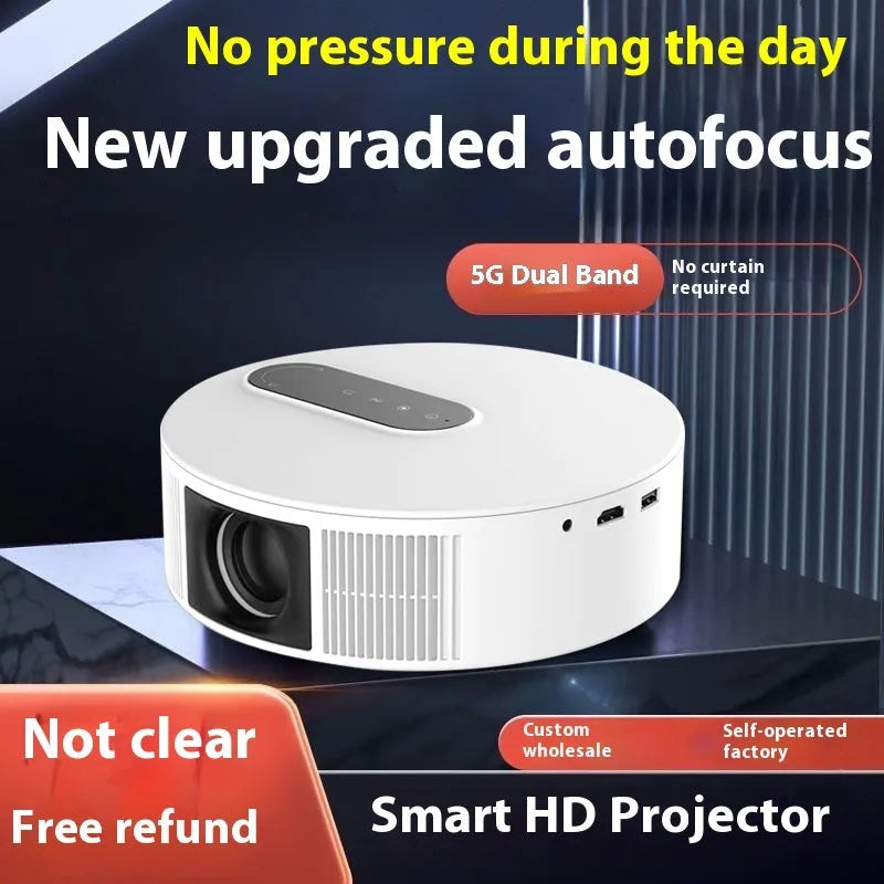 White HD home theatre projector with remote control on a wooden table.