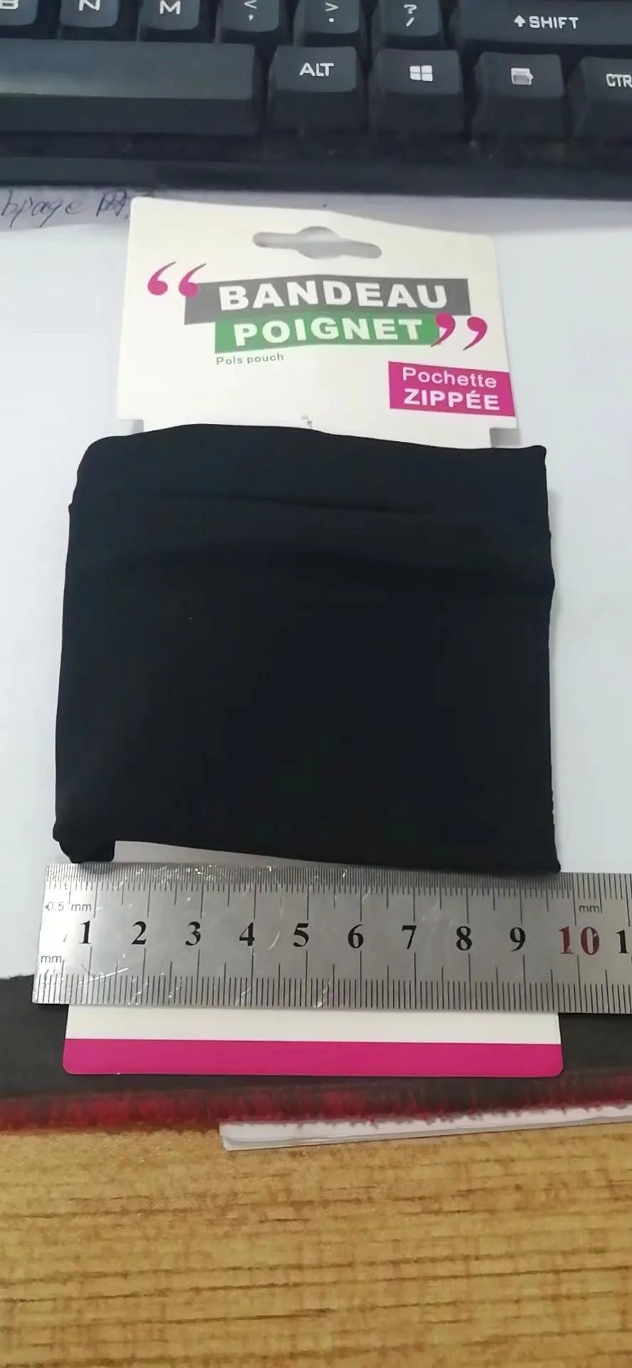 Compact black wrist bag armband sleeve for phone, shown with OPP packaging, dimensions 10cm by 10.5cm.