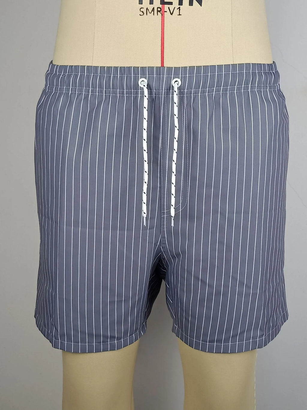 Men's navy blue polyester beach shorts with striped triangle lining and straight leg opening.