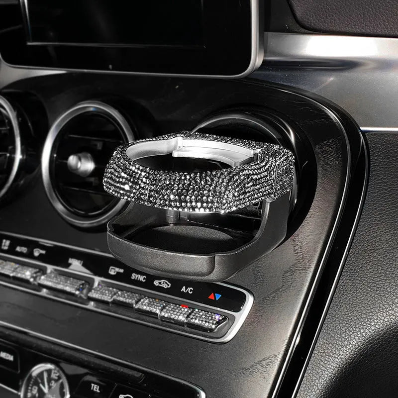 Rhinestone-encrusted white car cup holder bracket mounted on a vehicle air vent.