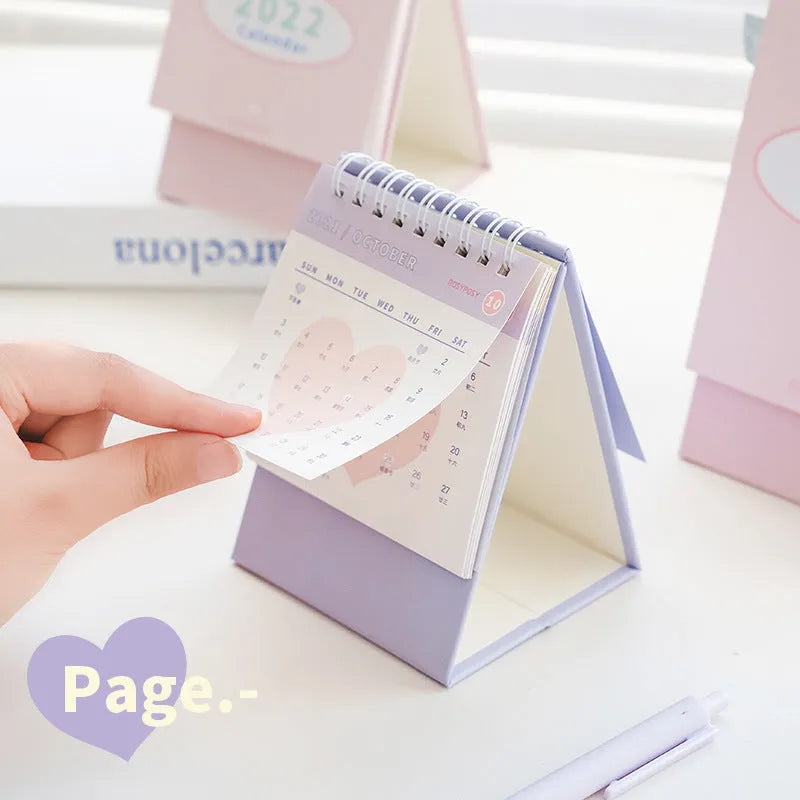 2022 paper desk calendar with coil binding, Regular or Professional size, in green, pink, purple, or yellow.