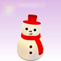Cartoon snowman shaped silicone night lamp with warm light on a desk