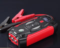 Red car emergency jump starter power pack with digital display and air pump inside a storage case.