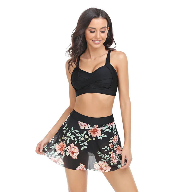 Women's one-piece swimsuit with an attached black tulle skirt, showing the split design.