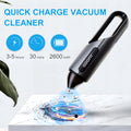Black portable wireless car vacuum cleaner with brush and flat attachments on vehicle seat