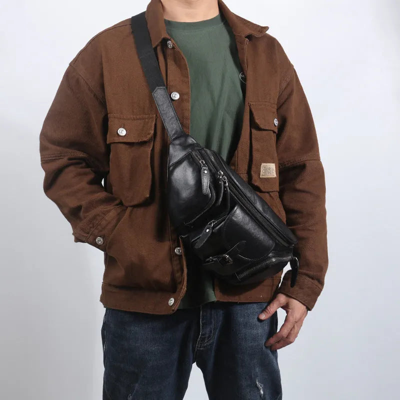 Black slanted chest bag in first layer cowhide with lock detail and polyester lining for daily commute