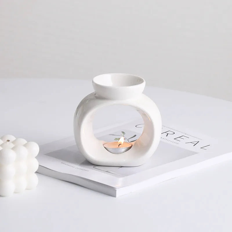 White Nordic style ceramic aromatherapy stove ornament on a wooden surface.