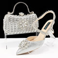 Women's black high heel shoe and matching clutch bag with floral rhinestone decoration and chain strap.