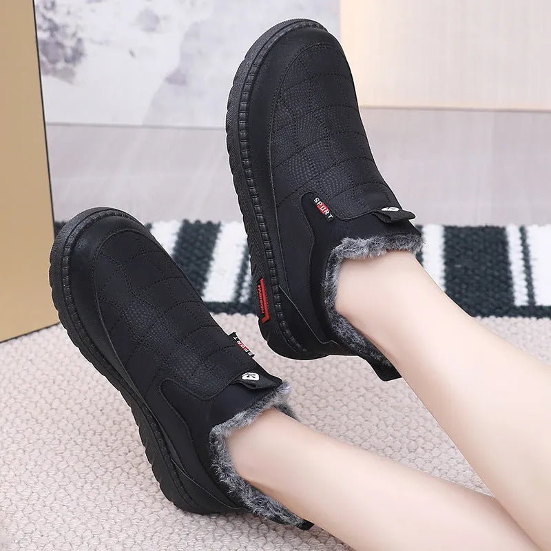Women's black casual flat boots with a round toe and low-top synthetic leather upper.