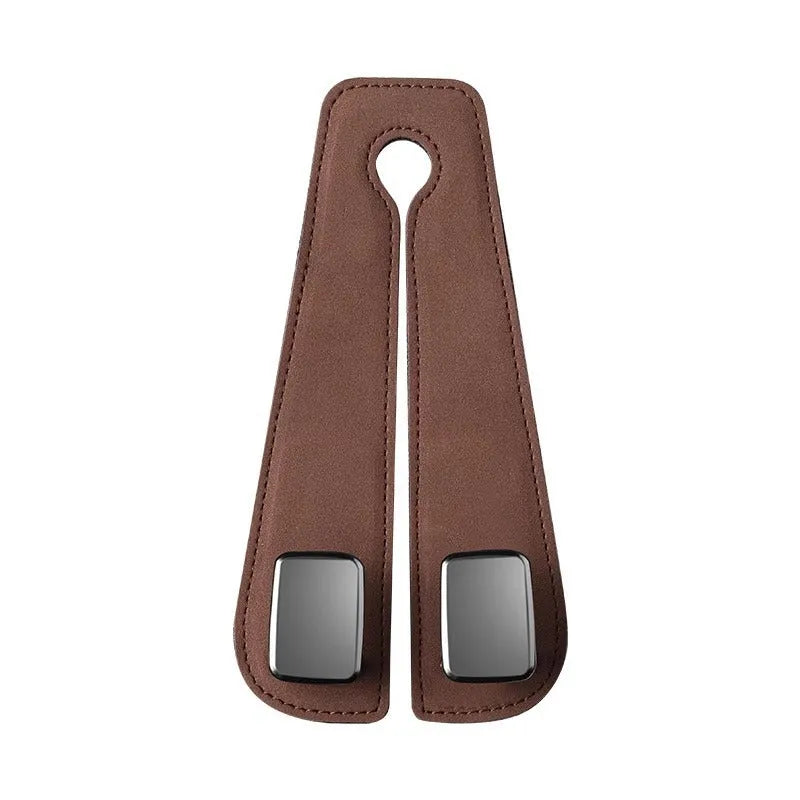 Black car seat hook with suede padding and flip-back design mounted on a grey car seat