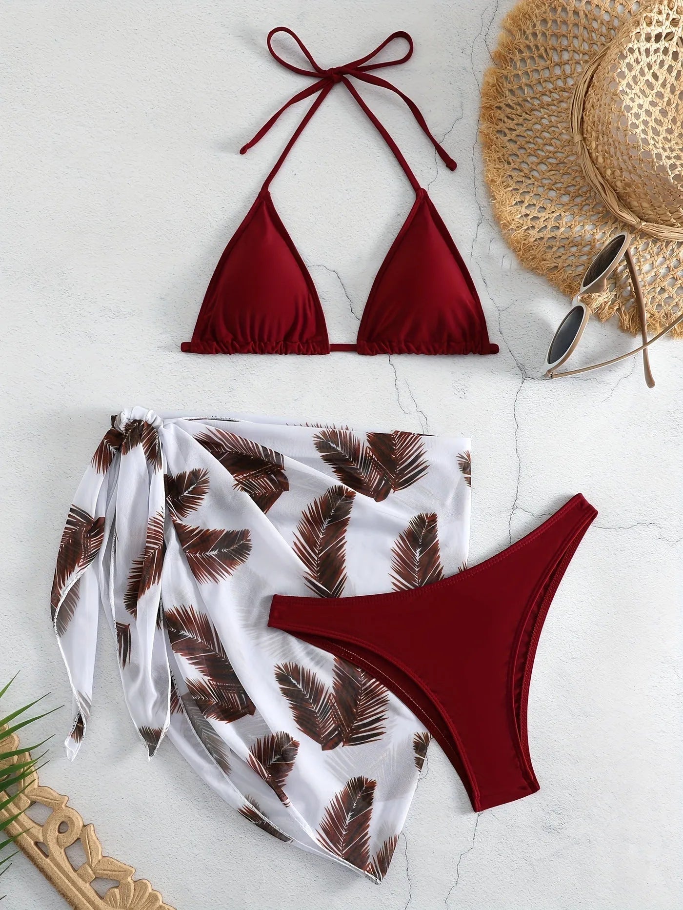 Orange three-piece bikini swimsuit set with a printed gauze skirt on a white background