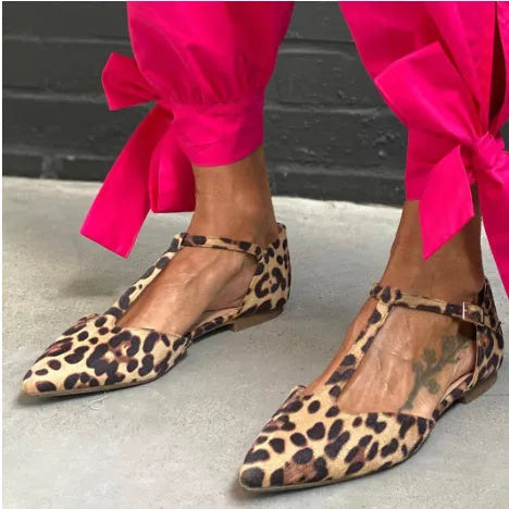 Leopard print women's pumps with pointed toe, cross shoulder straps, and a short chunky low heel.
