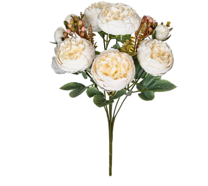 Artificial silk peony bouquet in a vase with champagne coloured blooms and green leaves