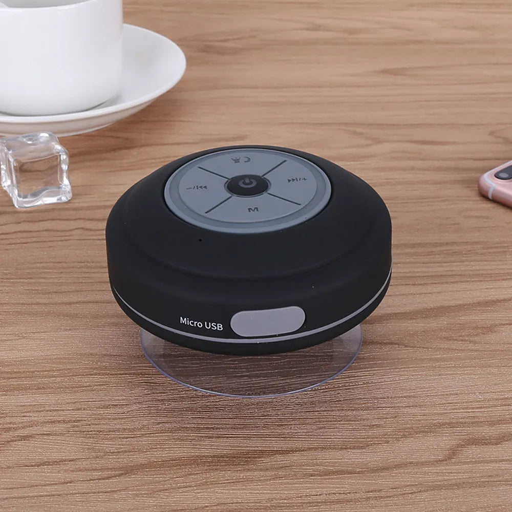 Waterproof suction cup Bluetooth speaker in black attached to a tiled wall