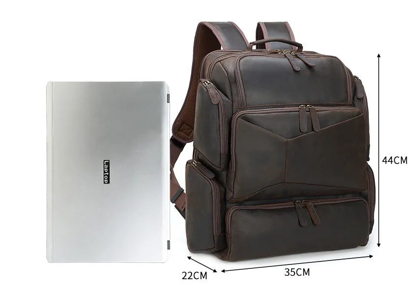 Dark brown genuine leather men's backpack open to show 17-inch laptop compartment and internal organiser pockets.