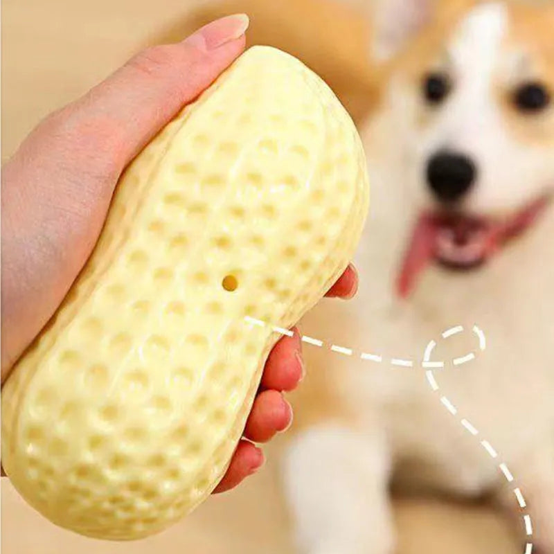 Yellow TPR peanut-shaped dog chew toy with textured shell on a white background.