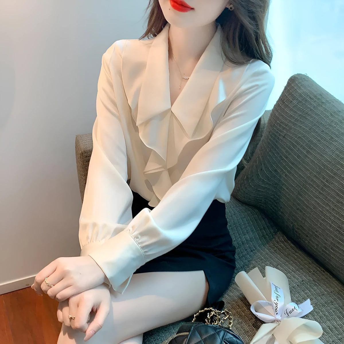 Ladies white chiffon blouse with long sleeves on a plain background
