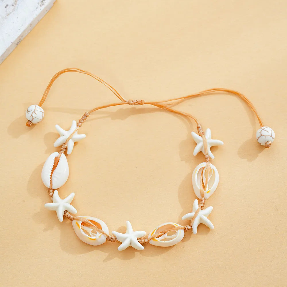 Hand-woven starfish shell cord bracelet in beige with shell arrangement