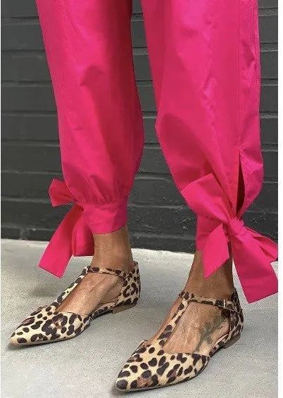 Leopard print women's pumps with pointed toe, cross shoulder straps, and a short chunky low heel.