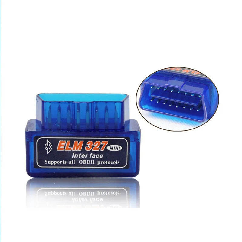 Small black ELM327 OBD2 Bluetooth diagnostic scanner next to a vehicle's OBD2 port.
