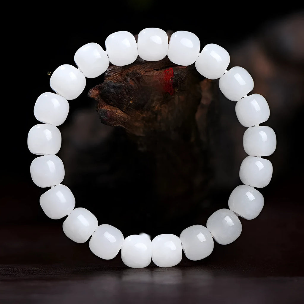 White Hetian jade barrel bead bracelet showing smooth, polished beads on a wrist.