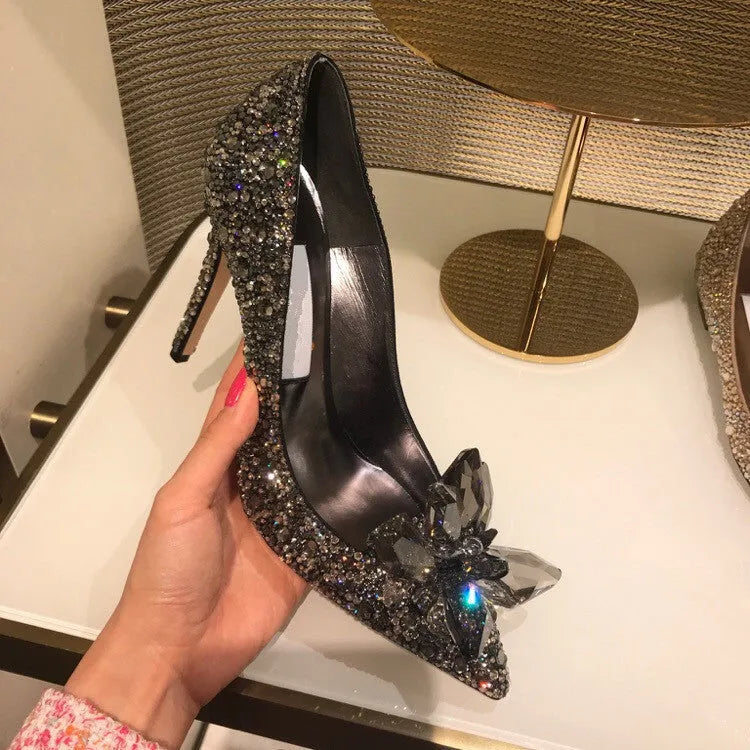 Gold women's pointed toe high heels with rhinestone and sequin decoration on a stiletto heel.