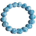 Blue handmade Bodhi bead bracelet with natural crystal and sea-pattern stone on a wrist.