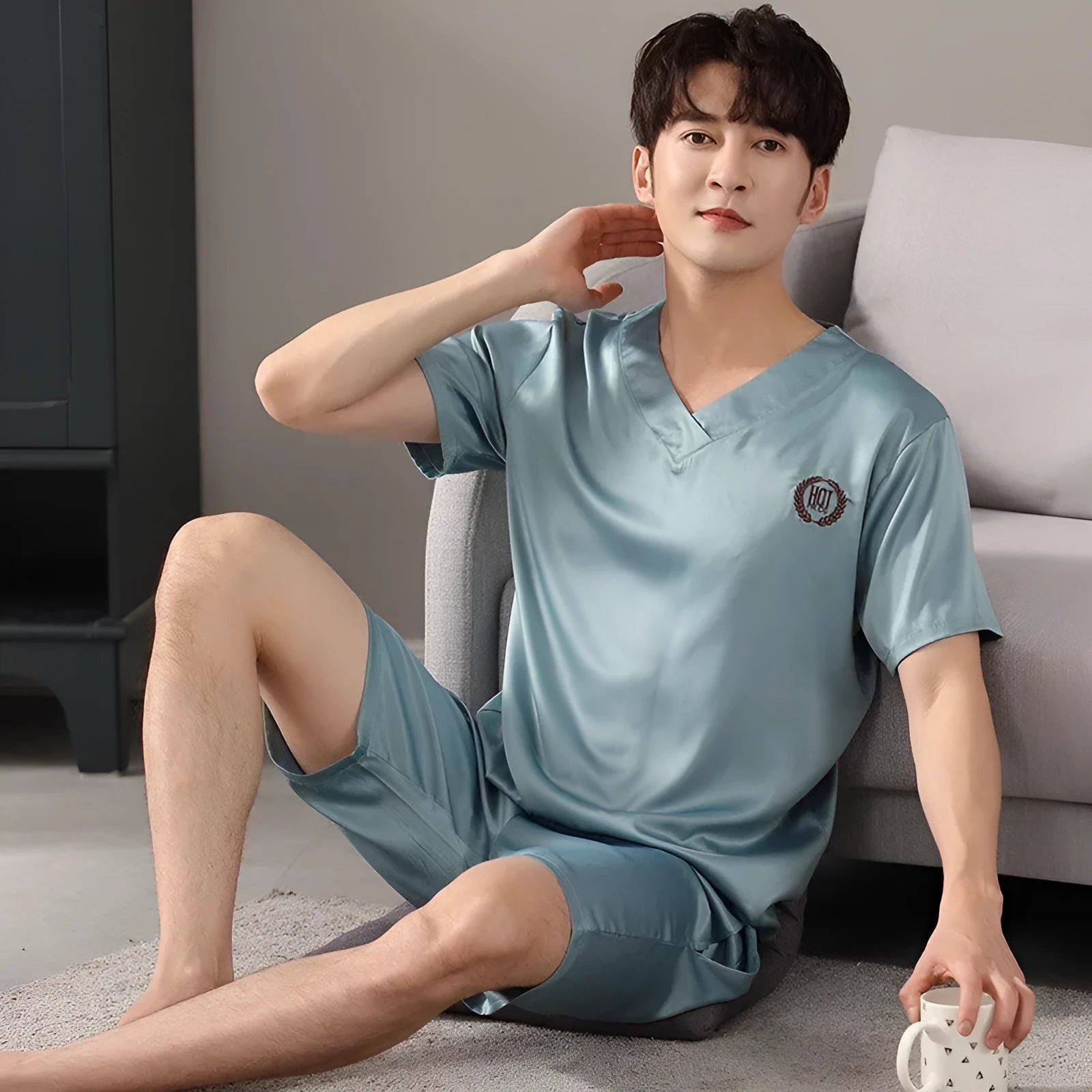 Man's loose-fitting ice silk pyjama set with short-sleeved shirt and shorts in a solid colour.
