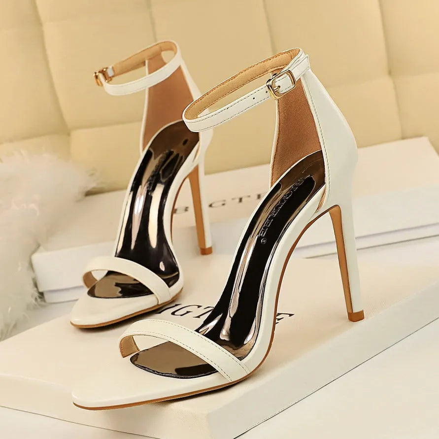 Women's open toe ankle-strap high heels with a buckle fastening, shown in one of six available colours.