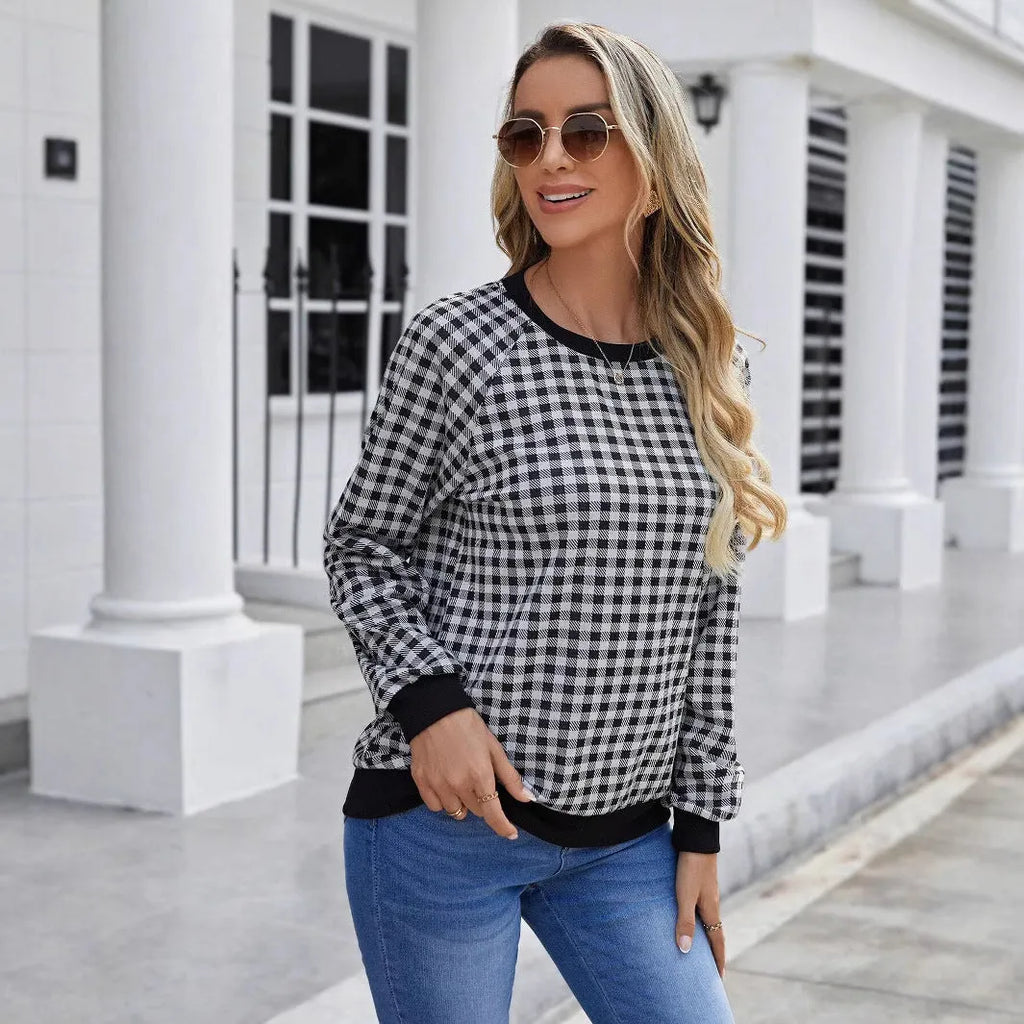 Black and white plaid print long sleeve pullover sweater for men on a neutral background.
