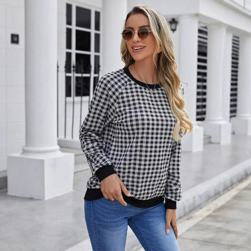 Black and white plaid print long sleeve pullover sweater for men on a neutral background.