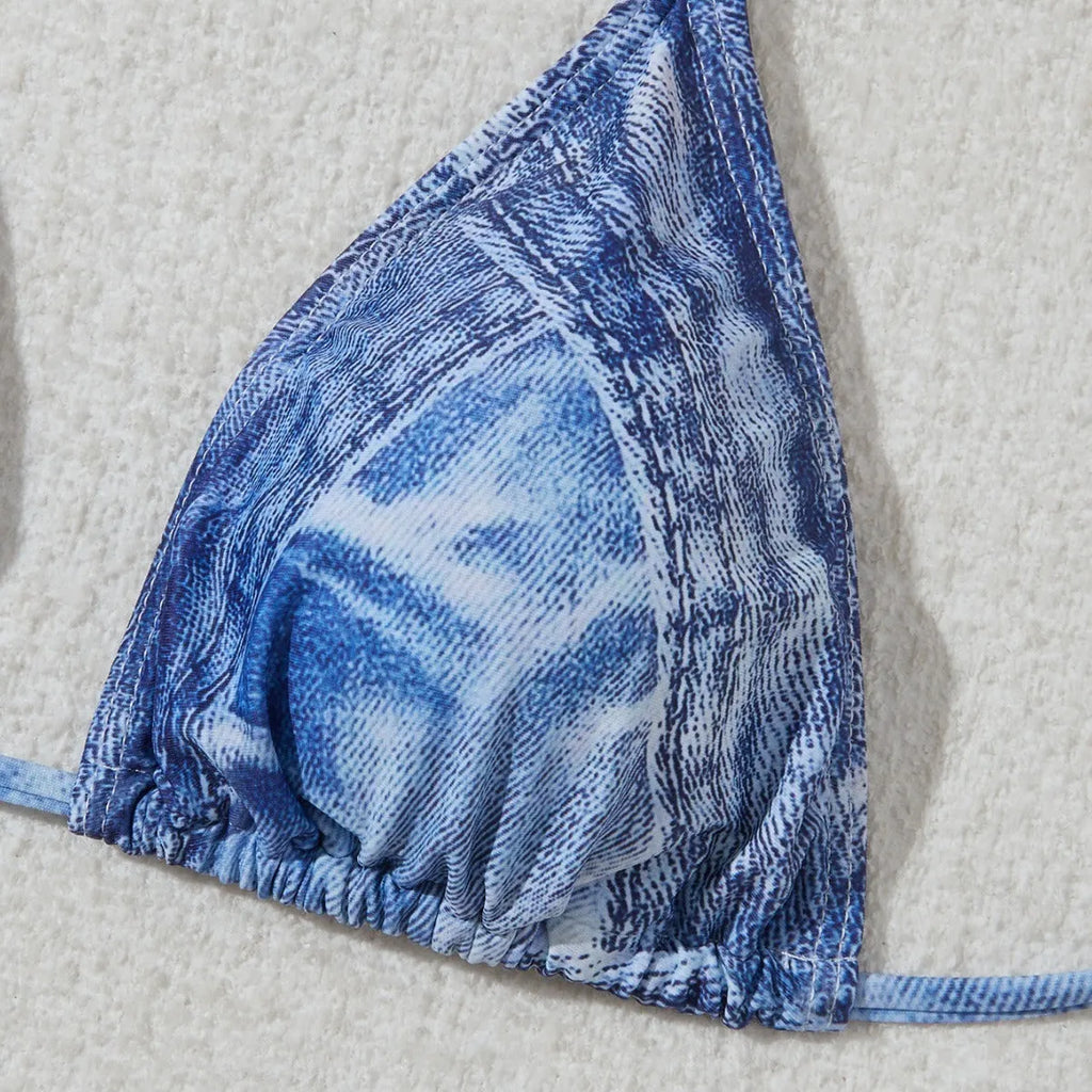 Women's denim blue printed bikini set with adjustable straps on a mannequin.