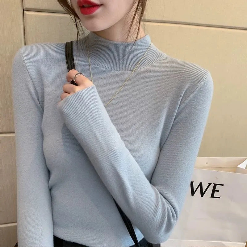 Slim fit knitted viscose top in apricot colour on a hanger, showing long sleeves and pullover design.