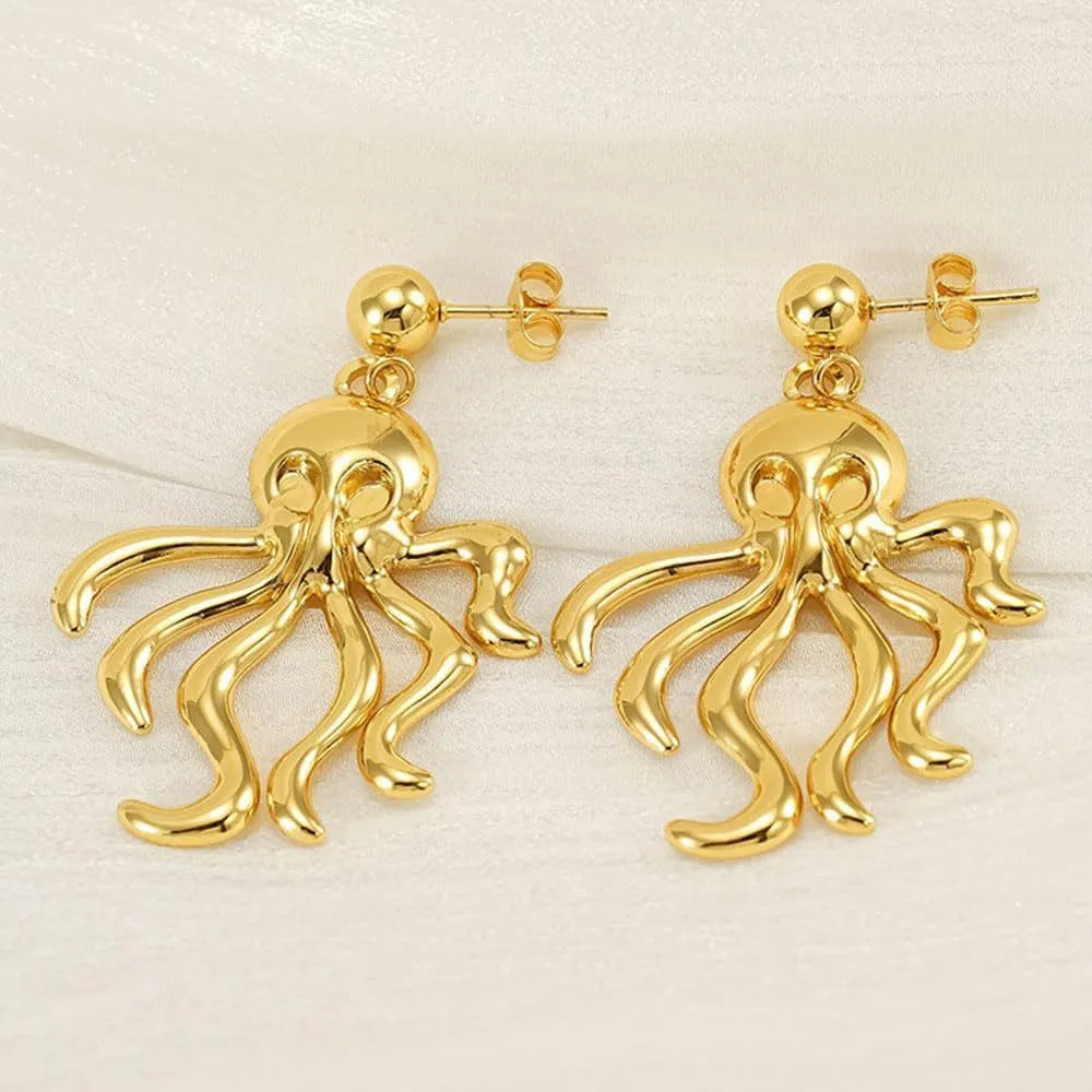 Gold stainless steel octopus drop earrings on a neutral background