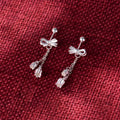 Silver bow ear studs with sweet tassel details and Korean style design for women