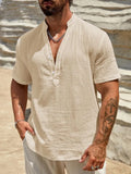 Men's solid colour short sleeve shirt with stand collar in light blue on a hanger.