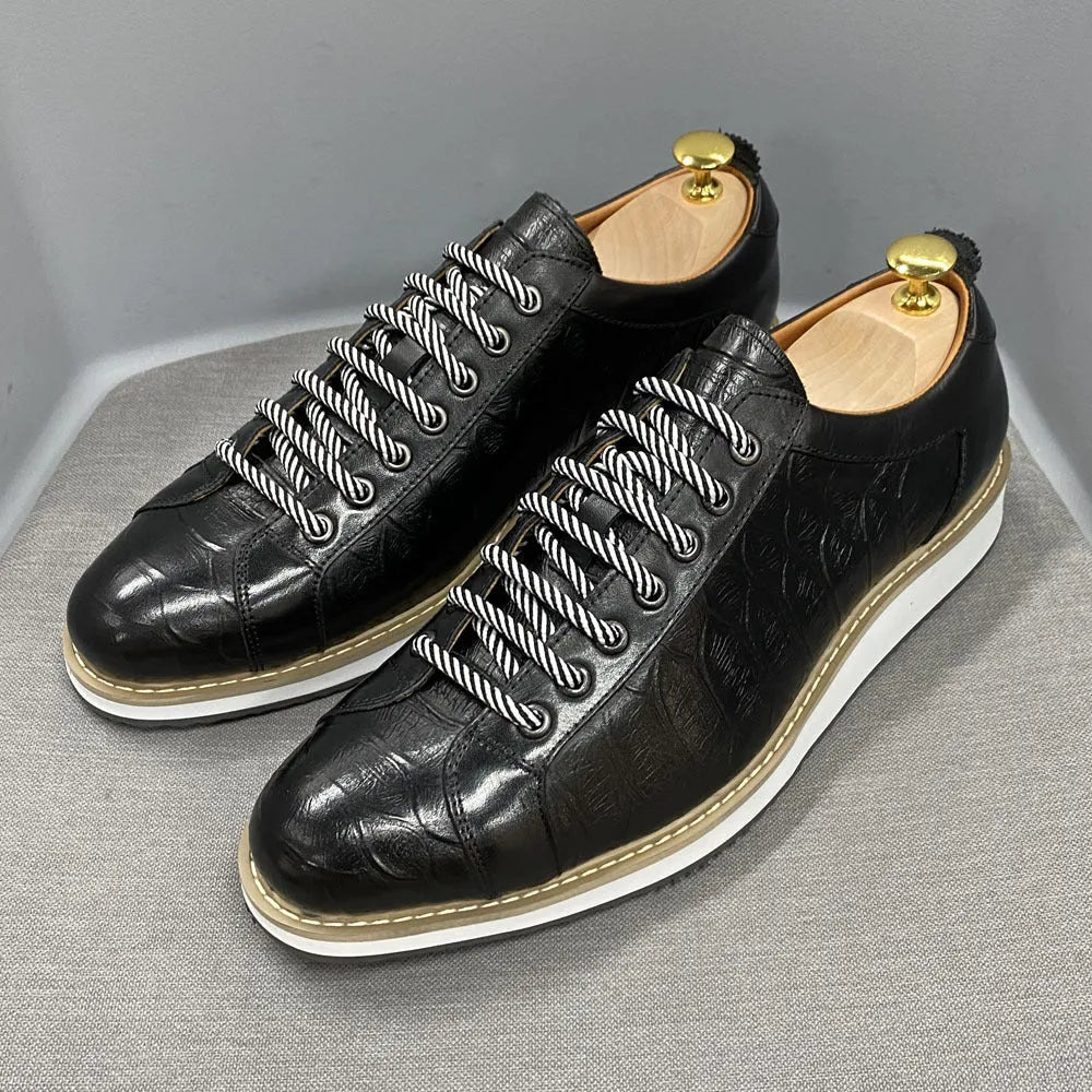 Men's low-top handmade shoes with embossed pattern detail on the upper and front lace closure.