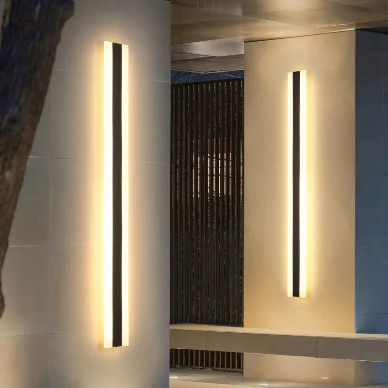 Straight outdoor LED wall lamp with wrought iron shell mounted on an exterior wall.