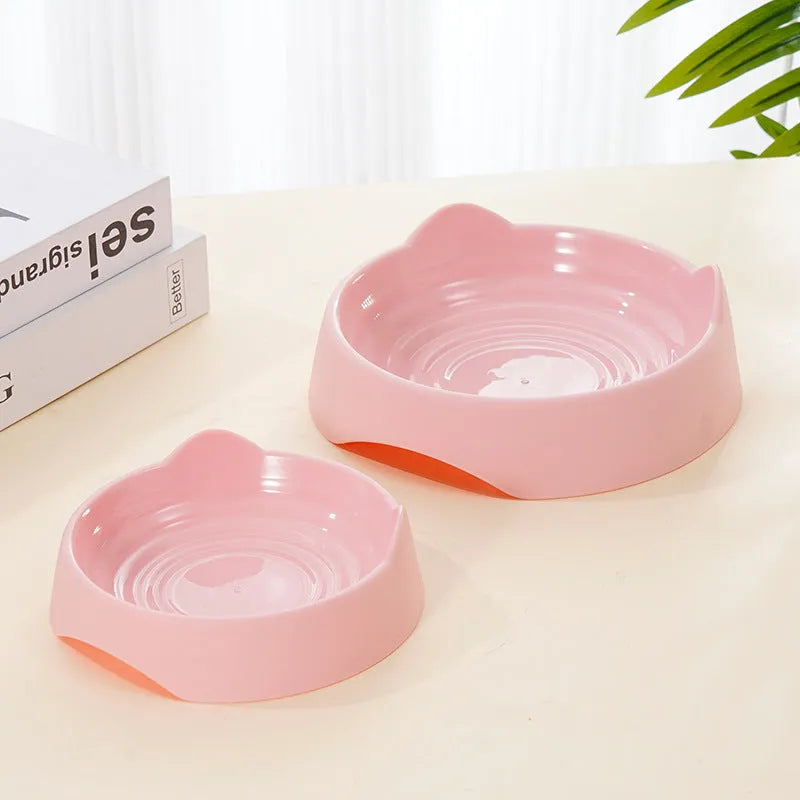 Blue ceramic dog slow feeder bowl with internal maze design, shown next to a green and pink version.