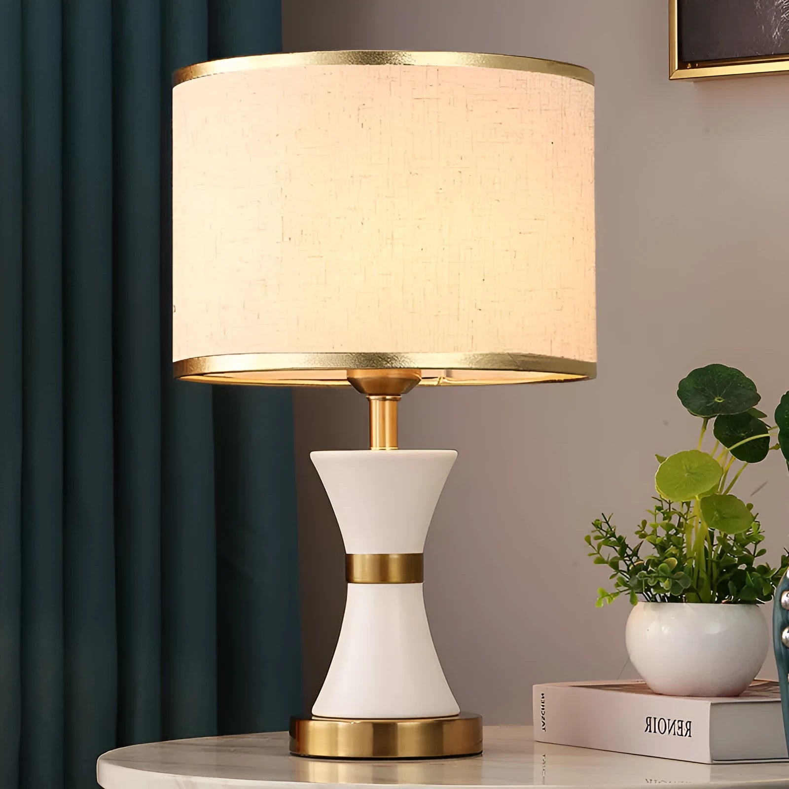 Iron table lamp with a white fabric shade and a push button switch on a wooden table.