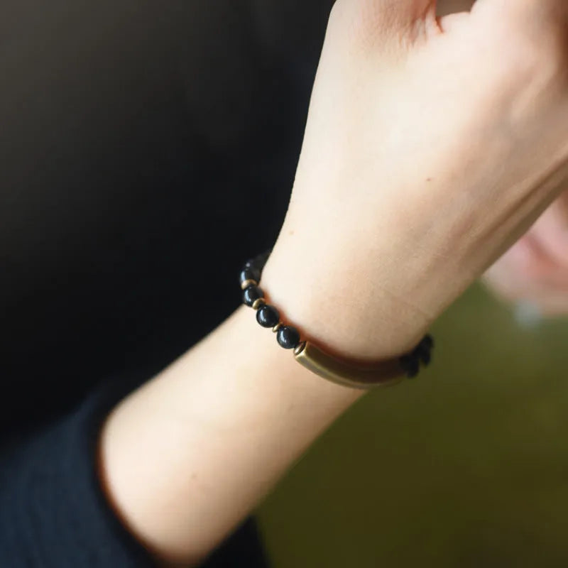 Layered retro bracelet with natural stone beads and brass details on a wrist.